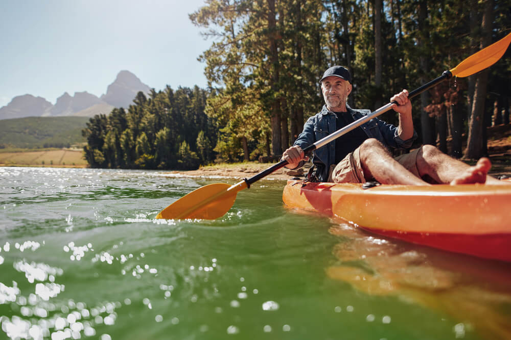Portrait of a mature man with enjoying kayaking in a lake