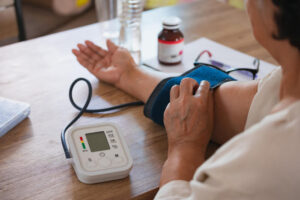 Senior woman is checking blood pressure and heart rate with digital pressure gauge